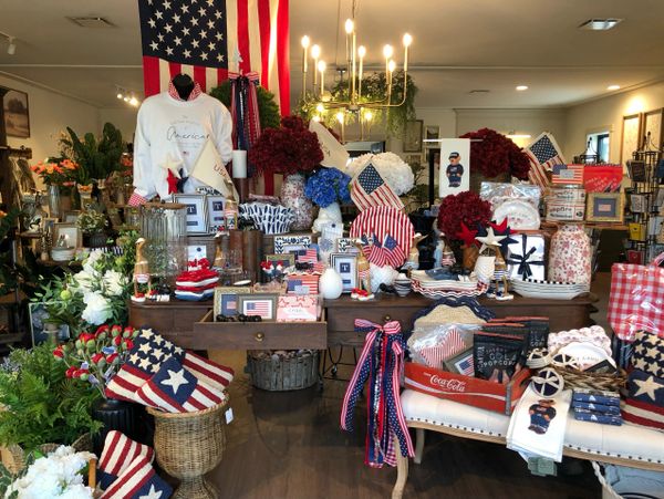 Patriotic-themed home decor and gifts with American flags and red, white, and blue colors.