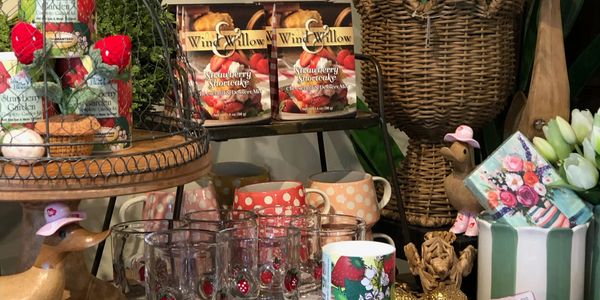 A cozy display of mugs, cookies, and decorative items with a strawberry theme.