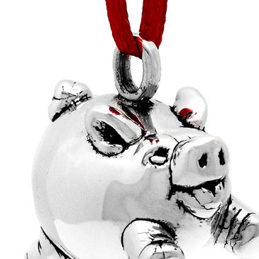 Silver pig ornament with red ribbon, isolated to highlight reflective surface and fine details