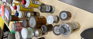 Collection of vintage metal and plastic cans on a table.