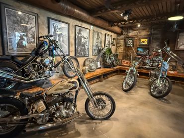 A rustic room showcasing vintage custom motorcycles and black-and-white motorcycle art.