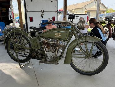 Vintage military-style motorcycle in olive green on display.