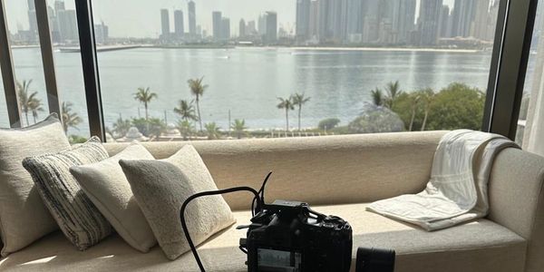 Camera setup on a tripod in a modern living room with a city skyline view.