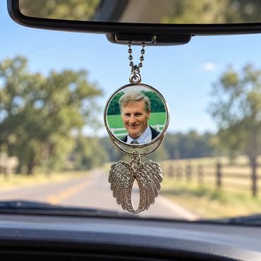 Rearview mirror with angel wing and photo charm.