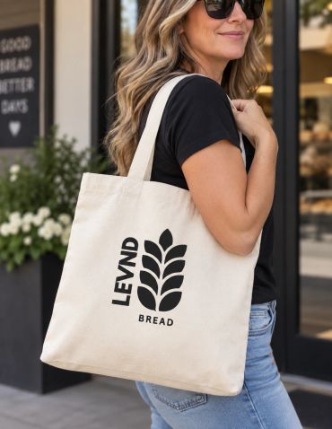 Woman with a tote bag reading 'LEVND BREAD'.