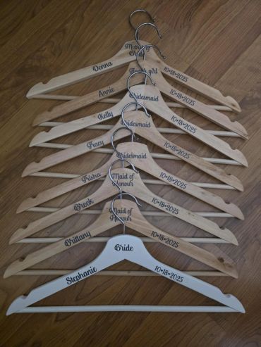Personalized wedding hangers with names and roles.