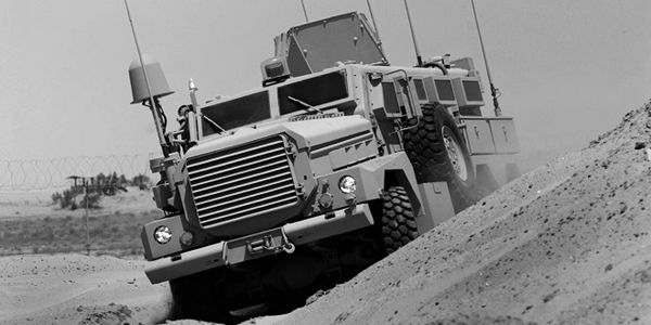 Military vehicle navigating rough terrain.