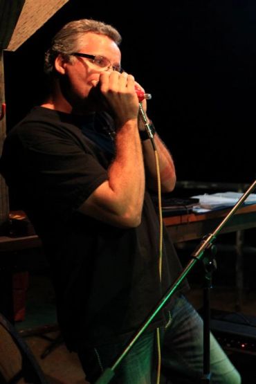 Man playing harmonica on stage.