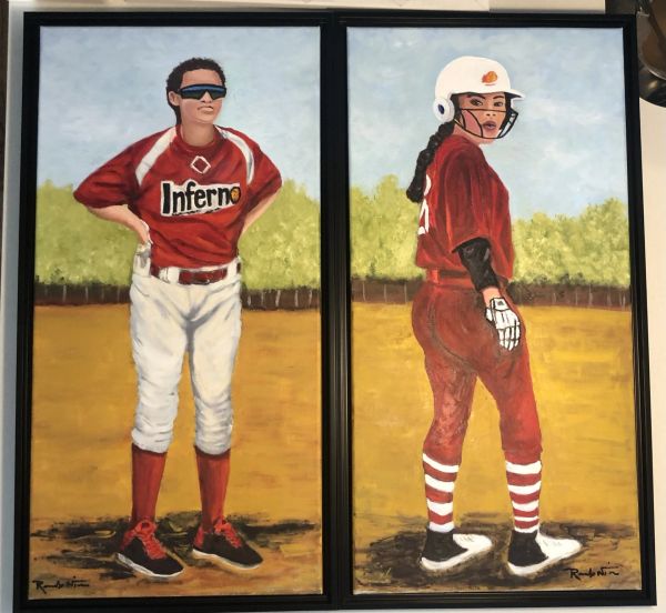 Two female softball players in red uniforms on a field.