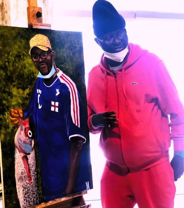 Man in pink outfit posing with his portrait painting.