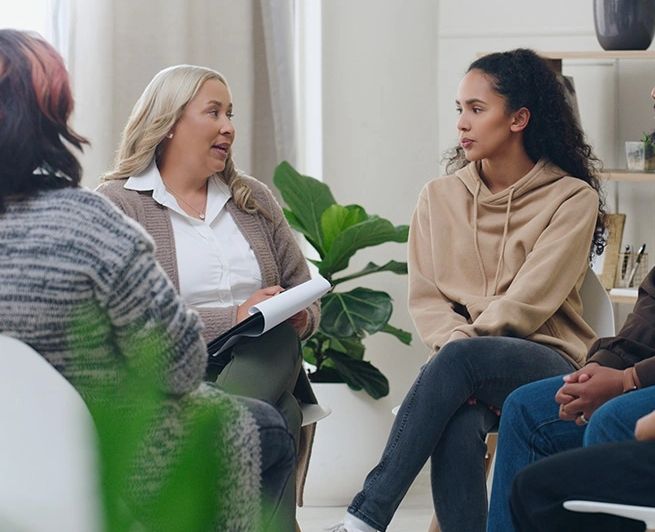 A group therapy session with attentive participants in a cozy room.