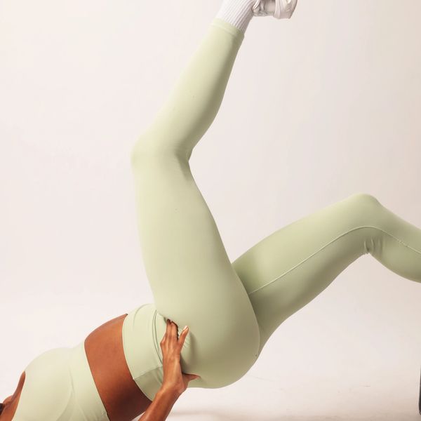 Person exercising in light green workout leggings.