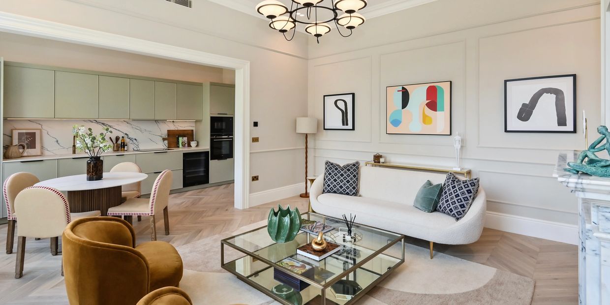 Modern heritage open plan living with sage kitchen, velvet chairs, boucle sofa, and coffee table 