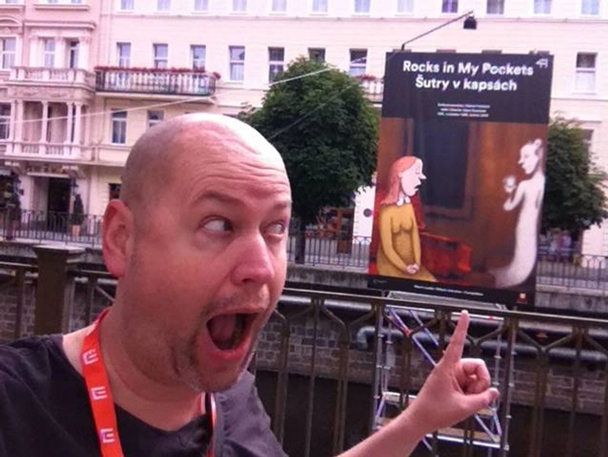 a man pointing to a banner 