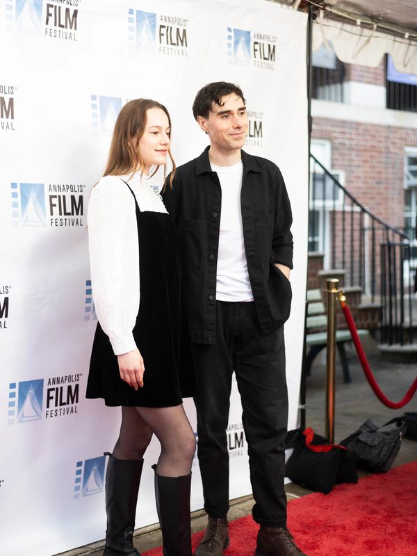 a man and a woman standing on a red carpet