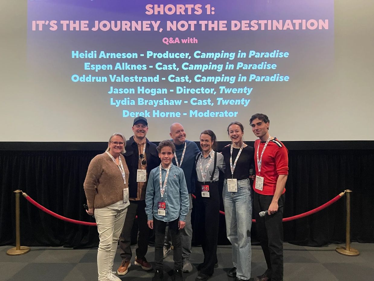 a group of seven people in front of a screen