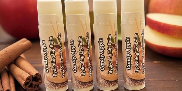 Candy Apple Hydrating Lip Balm tubes with apples and cinnamon sticks.