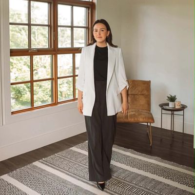 Femme élégante en tenue noir et blanc dans un intérieur lumineux.