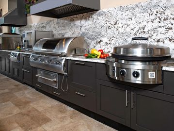 Modern outdoor kitchen with stainless steel appliances and granite countertops.
