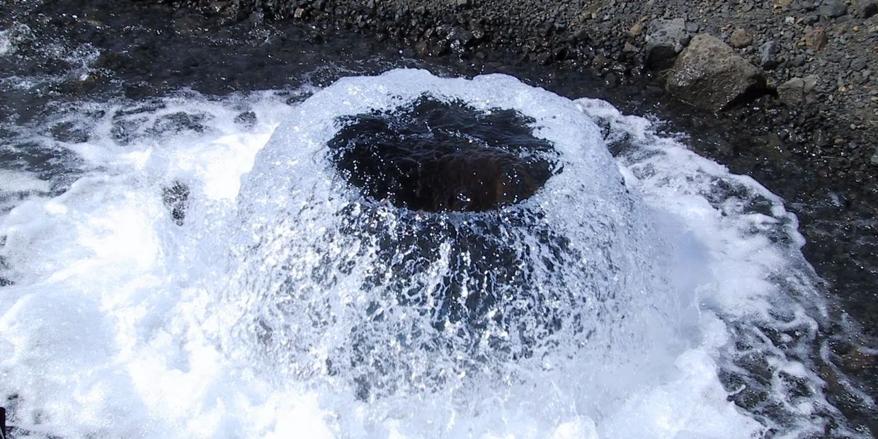 The natural spring water exiting the ground.  Photos show s it before water is capped with steal enc