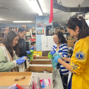 Group packing items with gloves in a warehouse.