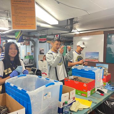 People organizing and packing items in a room.