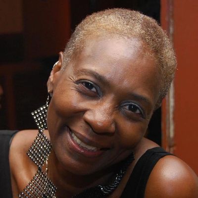 Smiling woman with short hair and statement earrings.