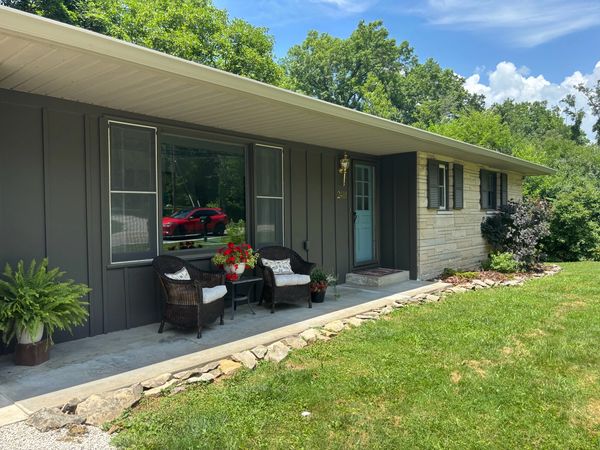 A cozy front porch with wicker chairs and plants at a suburban house.