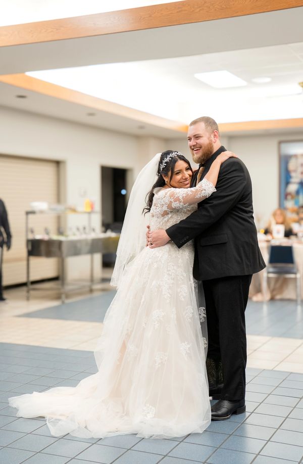 Bride and groom embrace happily during their wedding reception.