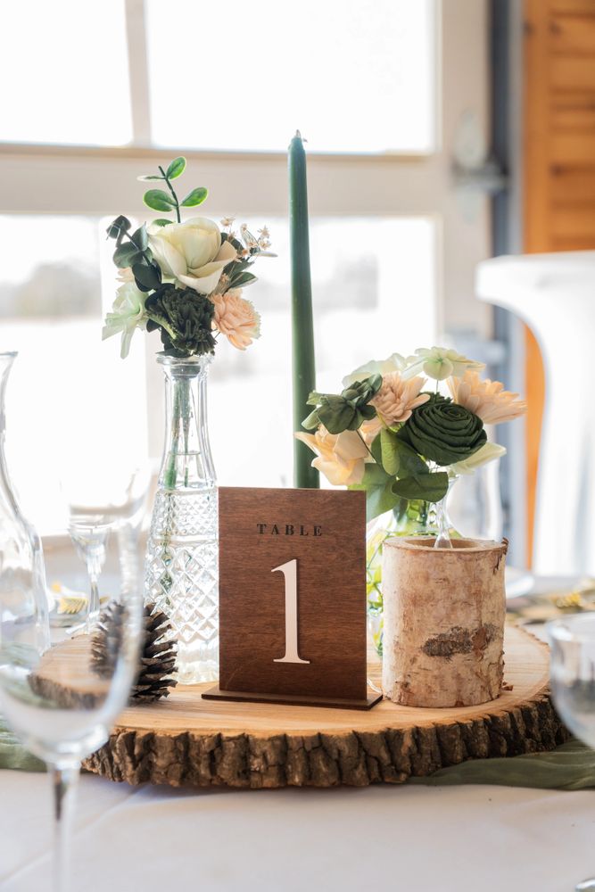 Rustic wedding table setup with flowers and wooden decor.