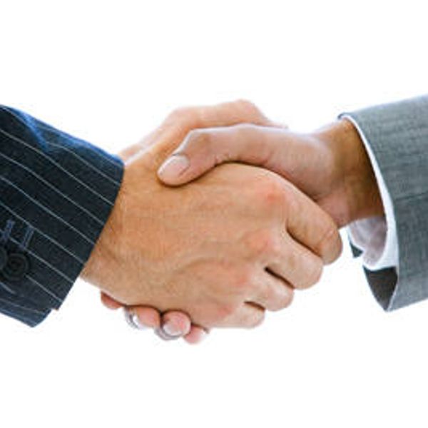 Two people shaking hands, symbolizing agreement or partnership.