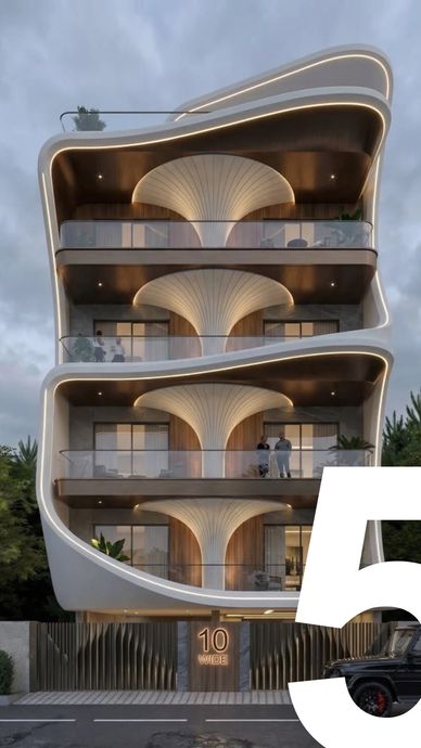Modern building with curved balconies and artistic lighting design.