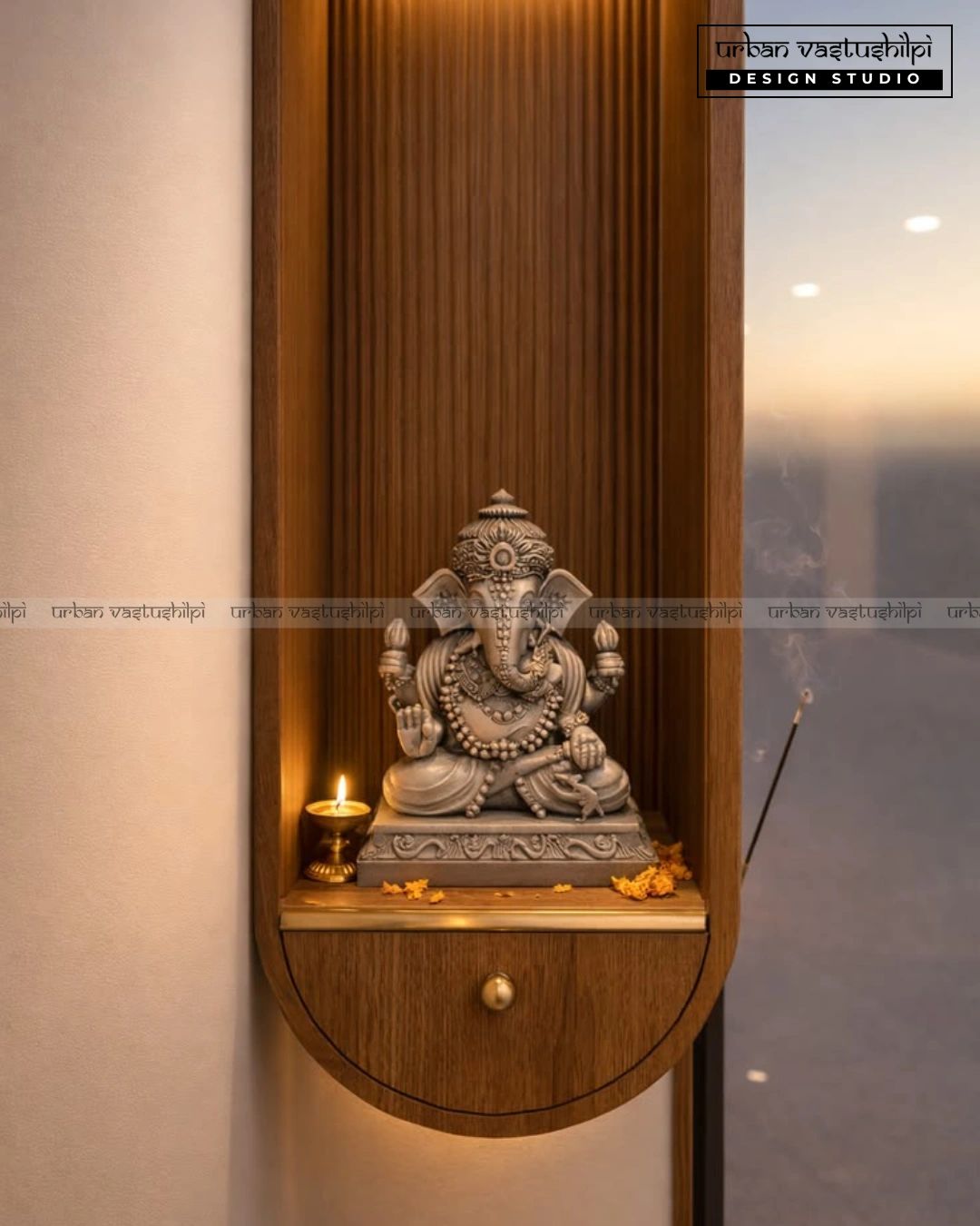Ganesha idol on wooden wall shelf with lit candle and incense.