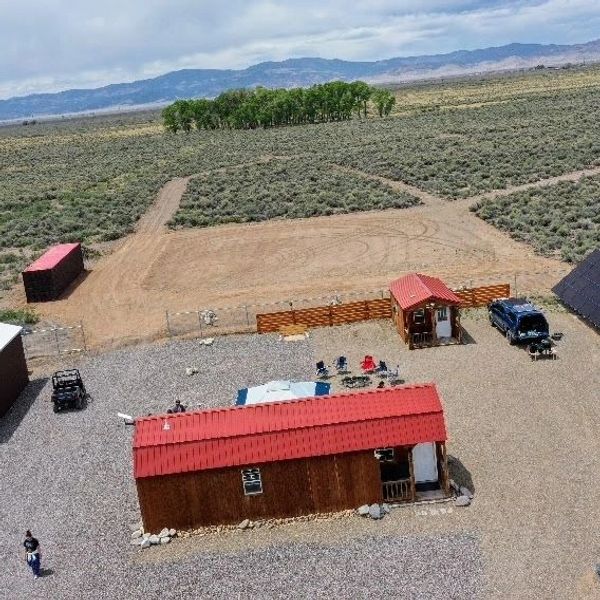 Aerial view of a rural property with red-roofed buildings and open land.