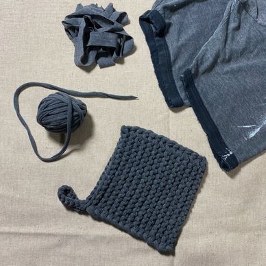 Handmade crochet pot holder made from recycled fabric strips and a pair of shorts.