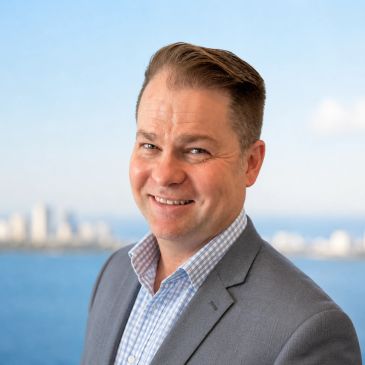 Smiling man in suit near the water.