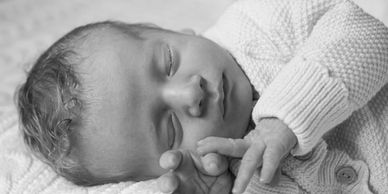 Sleeping newborn baby in cozy clothes.