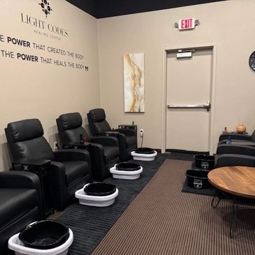 Interior of a spa with black massage chairs and foot baths.