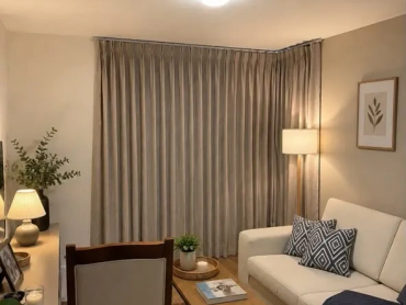 Cozy living room with beige curtains, a white sofa, and warm lighting.