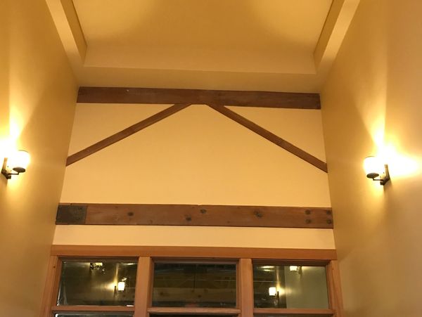High ceiling room with warm lighting and wooden beams.