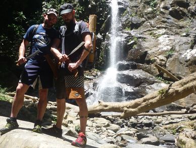 a group of people posing by the waterfall on a jungle survival trekking trip with lost borneo