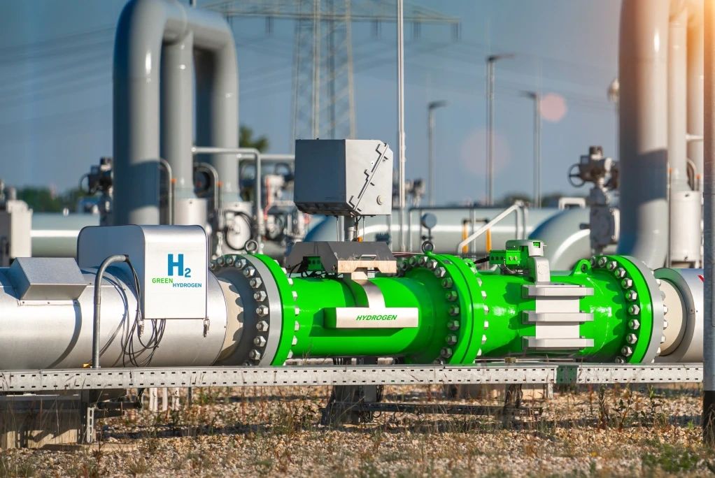 Green hydrogen pipeline and equipment in an industrial setting.