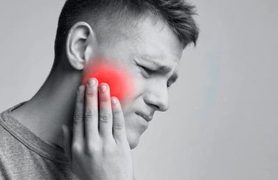 A yoing man experiencing jaw pain on his right side