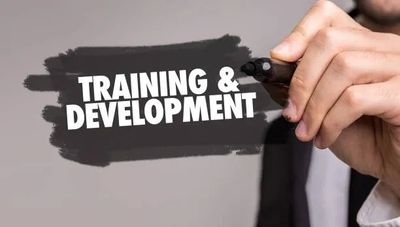 Hand writing 'Training &amp; Development' with a marker.
