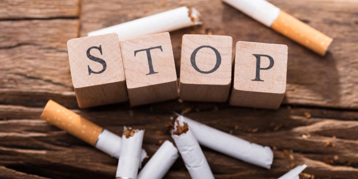 Broken cigarettes with block letters reading stop, hypnosis sessions for quitting smoking