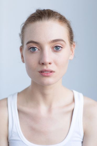 Close-up portrait of a young woman with blue eyes and light hair.
