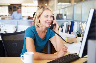 A person on the phone helping with benefit administration looking at her computer.