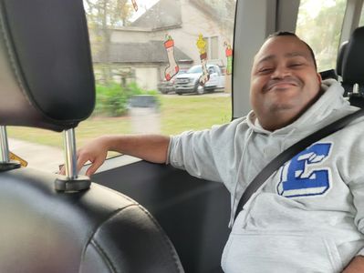 A man relaxing in a vehicle. He is smiling.