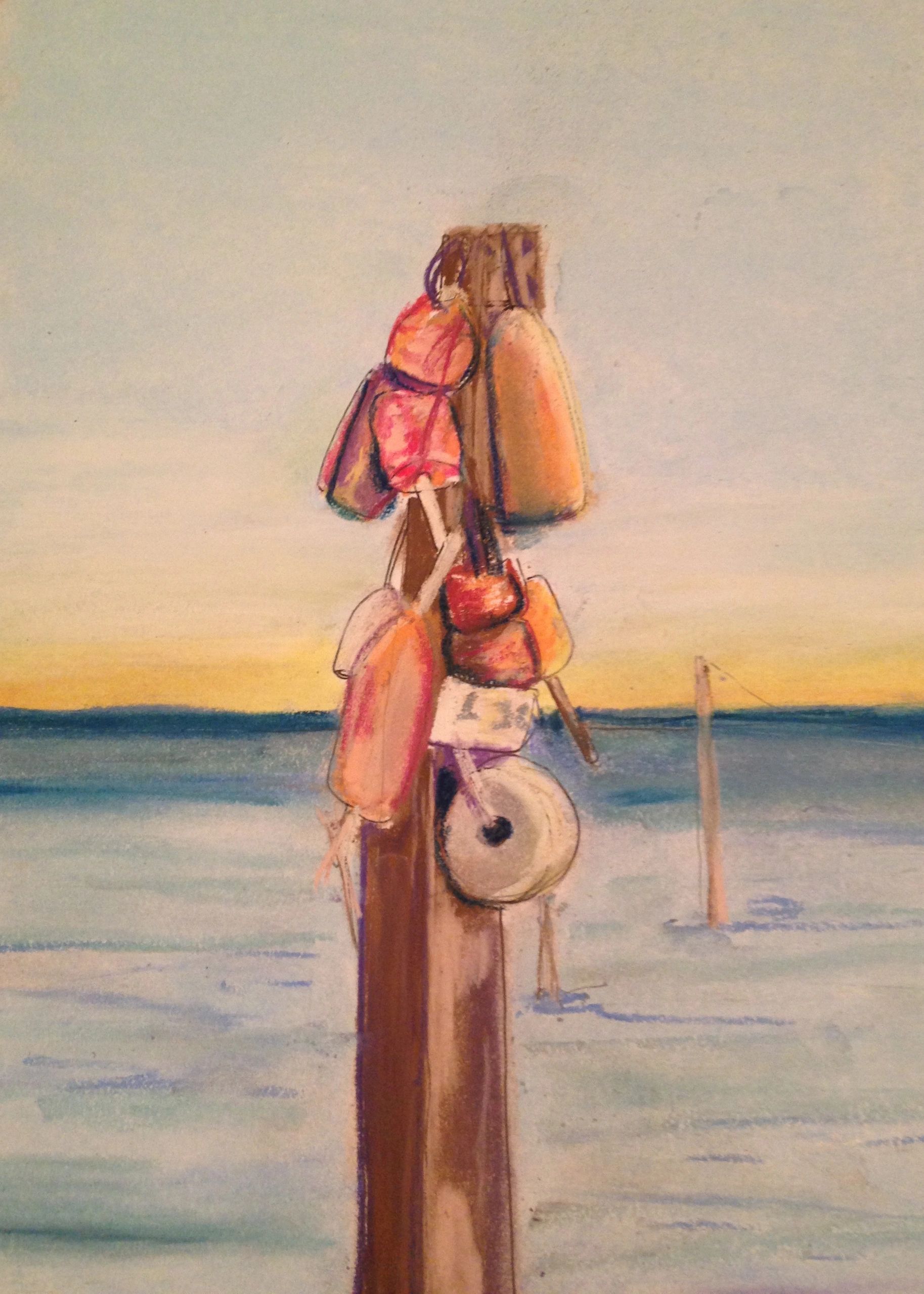 Buoys hanging on a wooden post by the sea at sunset.