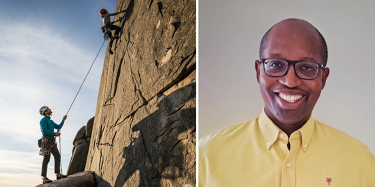 Two people rock climbing outdoors, one belaying the other.